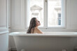 © Cavan Images - young woman in a vintage bathtub