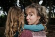 © Cavan Images - portrait of mother looking back whilst holding daughter