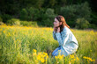 © Cavan Images - Portrait of confident young woman sitting in field