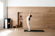 © Cavan Images - Attractive woman standing in Hasta Uttanasana pose, deflection back