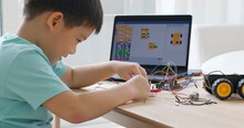 Asia Home School Young Small Kid Happy Smile Self Study Online Lesson Excited Make AI Circuit Toy. STEM STEAM Digital Scratch Class On Laptop Screen For Active Children Play Arduino Enjoy Fun Hobby.