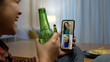 © ChayTee - Young happy attractive asia female enjoy relax night party event online celebration festive with friends at home sofa pr table clinking beer with glass and bottle drinking via online videocall.