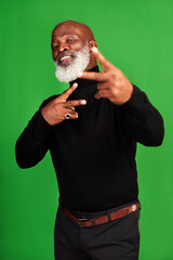 Poster - Show me someone cooler than me. Studio shot of a senior man showing peace signs while posing against a green background.