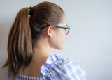 Fototapeta  - Young woman with ponytail hairstyle from side view. Women commonly wear their hair in ponytails in informal and office settings or when exercising.