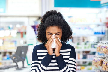 Canvas Print - Got the flu Weve got just the remedy for you. Shot of a young woman blowing her nose in a pharmacy.