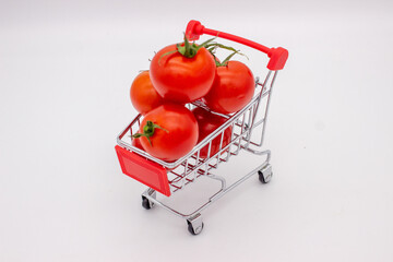 Tomatoes in metal basket on white background