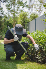 An Asian male shoveling in the backyard.