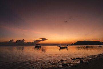 Wall Mural - silhouettes of fishing boats on the sea at a beautiful sunset