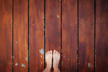 Personal Perspective Or Low Section Selfie Of Asian Woman, Focus On Bare Feet Standing On Wooden Plank With Copy Space.