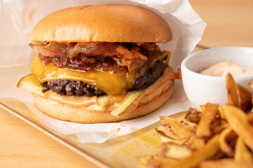 Wall Mural - close up of juicy fresh cheeseburger  with fries and sauce