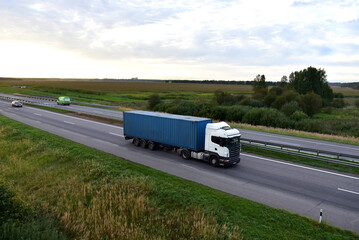 Semi Truck transport the Shipping container on highway. Shipping Containers Delivery, Maritime Services and Transport logistics.