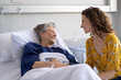 Woman visiting senior mother in hospital