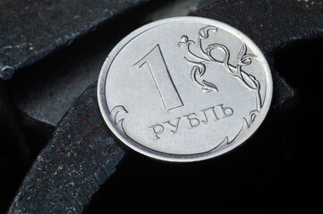 Russian coin denominated 1 ruble. shines on a scratched metal surface. close-up. translation of the text on the coin 