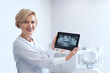 © brizmaker - Dentist holding digital tablet with teeth x-rays