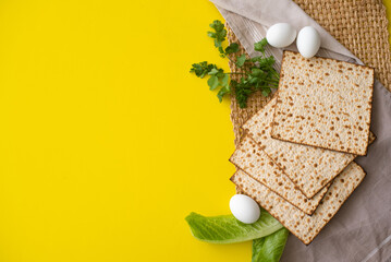 Banner. Layout of  Traditional Matzah prepared for Passover with egg, green salad and parsley on yellow background. top view. Spring Holiday of Jewish people. Fasting time. Space for text.