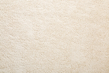 beige new fluffy home carpet background. closeup. empty place for text. top down view.