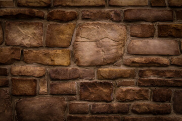 Wall Mural - old odd shaped tan and brown thick cut stone block wall