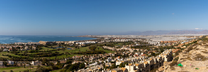 Poster - panorama view of the coastline at Almerimar with hotels and golf courses and beaches and trash in the foreground