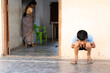 Kid sitting outiside the calss by holding ears as punishment - concept of childhood mischief and education and learning