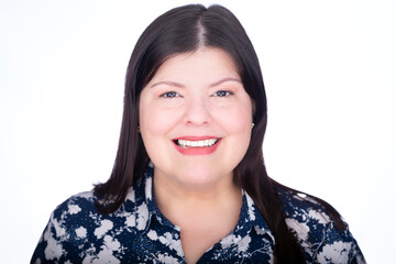 Headshot closeup of a beautiful latin lady. She is standing facing the camera over white background while she is smiling