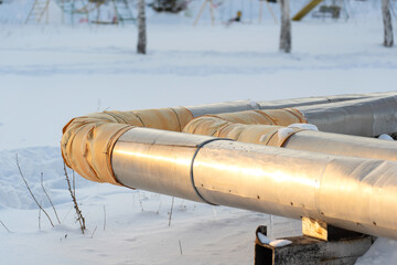 central heating pipes sheathed with aluminum sheets and a repair patch made of yellow insulating mat