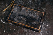 Empty black rustic kitchen board with flour on black background.