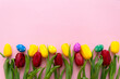 © Inna - beautiful tulips, decorated Easter eggs on color pink background, top view