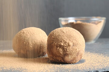 Canvas Print - chocolate cake dessert in the shape of a ball of a circle sprinkled with cocoa powder. homemade dessert day of chocolate sweet tooth. a day without diet