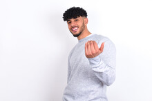 Young Arab Man With Curly Hair Wearing Sport Sweatshirt
Over White Background Inviting To Come With Hand. Happy That You Came