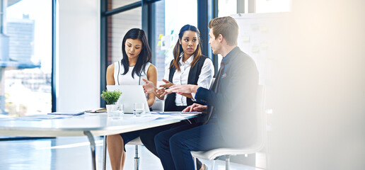 Poster - Exchanging ideas to get the best result. Cropped shot of a group of young businesspeople having a discussion while using a laptop in a modern office.