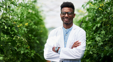 Poster - Plants are living organisms that need caring like us all. Portrait of a handsome young botanist posing with his arms folded outdoors in nature.