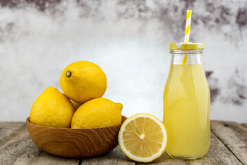 Wall Mural - Fresh lemons and lemonade in glass bottle