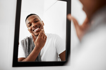 Canvas Print - No irritation, no redness. Cropped shot of a young man touching his face while looking into the bathroom mirror.