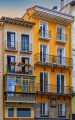 Poster - Colorful house facades and ornate metal balconies with flowers in the old town or Casco Viejo in Pamplona, Spain famous for running of the bulls