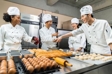 Asian Chefs  baker in a chef dress and hat, cooking together in kitchen.Team of professional cooks in uniform preparing meals for a restaurant in the kitchen.