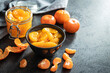 Canned tangerine. Pickled mandarin fruit in bowl on black table.