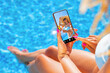 © Kaspars Grinvalds - Woman using video sharing social media app on mobile phone while sitting by the pool