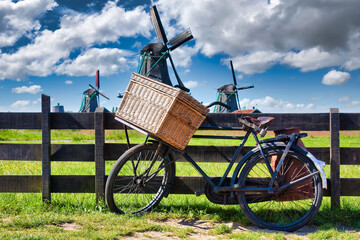 Bicycle with windmill and blue sky background. Scenic countryside landscape close to Amsterdam in the Netherlands.