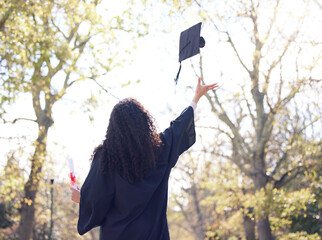 Wall Mural - A bright future is about to begin. Rearview shot of a young woman throwing her cap in the air on graduation day.