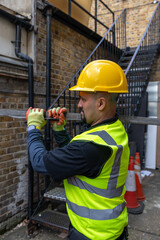 Wall Mural - A construction working working in a building site carrying a metal bar on his shoulder.