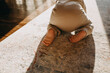 Closeup of baby barefoot feet on a carpet. Baby crawling on knees on the floor at home.
