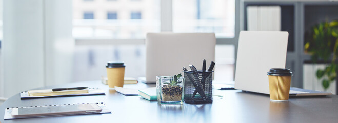 Poster - Ready for a busy business day. Shot of technology, takeaway coffee cups and office supplies on a desk in an empty office during the day.