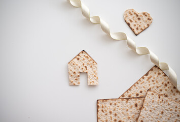 Wall Mural - Layout of Matzah shape of small house, hearts and tape on white background. Traditional of Jewish Holiday on Passover. Home symbol of happy family. Purchase or rent. top view. Real Estate Agency