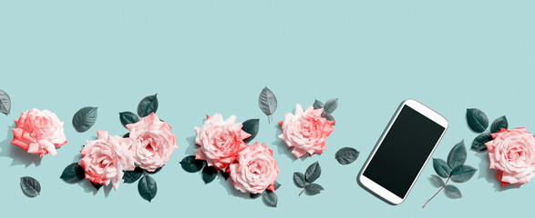 Smartphone with pink roses overhead view - flat lay