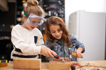 Wall Mural - Playing with dads tools is the best. Shot of two little girls busy at work on creating something with tools.