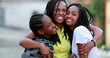 © Marco - Funny mother hugging daughters outside. African black ethnicity family love and affection