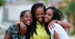 © Marco - Funny mother hugging daughters outside. African black ethnicity family love and affection