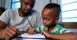 © Marco - Father mentoring son, dad helping kid with homework study