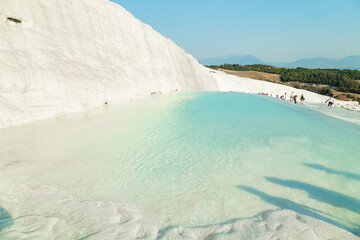 Wall Mural - Natural travertine pools and terraces in Pamukkale. Cotton castle in southwestern Turkey. Tourists walking and bathing in Natural travertine pools