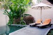Relax concept. Cozy and comfortable sun beds and beach umbrellas near the swimming pool. Summer vacations still life.